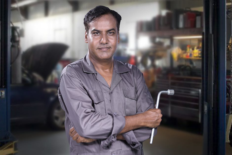 Friendly auto mechanic standing next to a vehicle with newly replaced auto glass